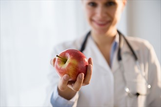 Portrait of doctor giving apple