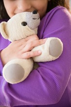 Girl (8-9) holding teddy bear