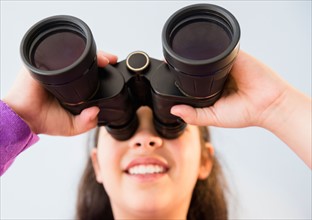 Girl (8-9) using binoculars