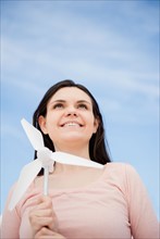 Portrait of young woman holding minature wind turbine