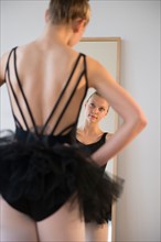 Rear view of teenage (16-17) ballerina looking into mirror