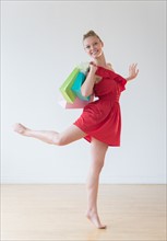 Portrait of teenage (16-17) ballerina with colorful shopping bags