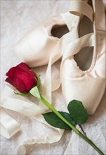 Studio Shot of pair of ballet shoes and red rose