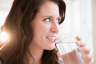 Portrait of young woman holding glass of water