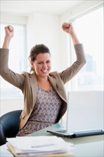 Portrait of cheering woman in office