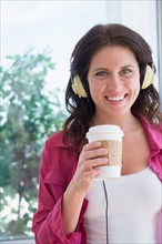 Portrait of woman with coffee cup and headphones
