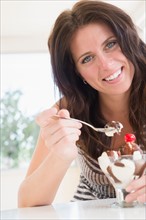 Portrait of woman eating ice cream sundae