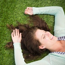 Happy woman lying on grass