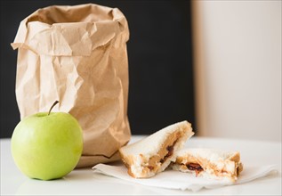 Studio Shot of green apple and sandwich next to paper bag