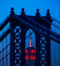 Williamsburg Bridge in front of Empire State Building at night
