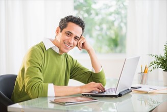 Portrait of man working on laptop at home