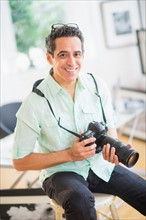 Portrait of man holding photo camera