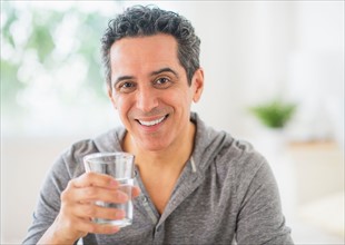 Portrait of mature man holding glass of water