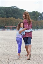 Woman and her daughter (8-9) on playground