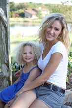 Mother with daughter (4-5) sitting outdoors