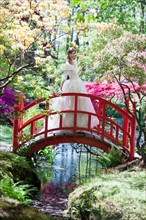 Bride standing on garden bridge