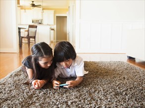 Siblings (8-9) playing mobile phone game