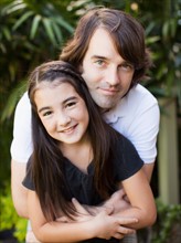Portrait of father hugging daughter (8-9)