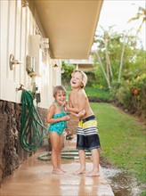Children (2-3, 6-7) refreshing at outdoor shower