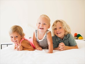Portrait of boy (6-7), girl (2-3) and their baby brother (6-11 months)