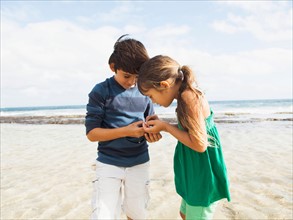 Portrait of girl (6-7) and boy (10-11) on beach