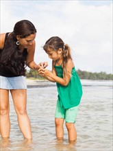 Girl (6-7) with mother walking in sea