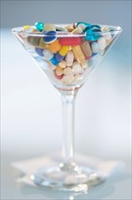Studio shot of colorful pills in martini glass.