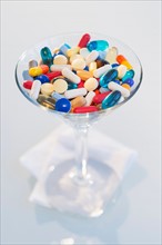 Studio shot of colorful pills in martini glass.