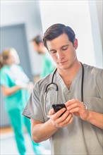 Male doctor texting on phone.