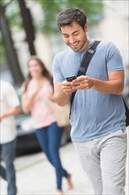 Man texting in street.