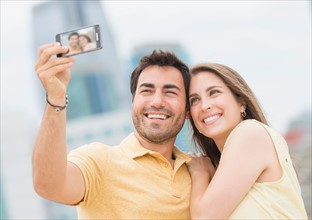 Couple taking self portrait photo with smartphone.