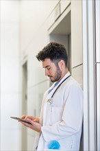 Doctor using digital tablet in hospital.
