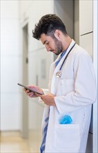 Doctor using digital tablet in hospital.
