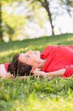 Mature woman lying on grass.