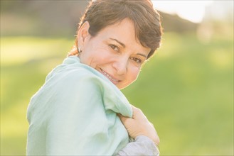 Portrait of mature woman smiling outdoors.