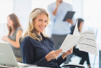 Woman smiling at desk in office.