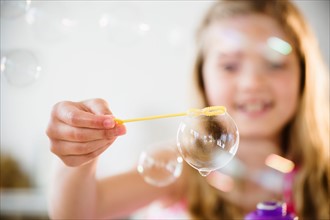 Girl (8-9) playing with bubbles