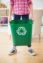 Close up of girl (8-9) holding recycle bin