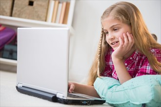 Girl (8-9) using laptop