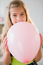 Girl (8-9) with pink balloon