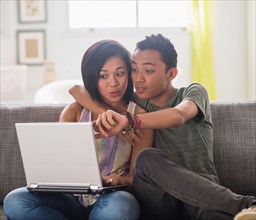 Young woman and young man using laptop