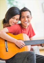 Portrait of young couple, man holding guitar