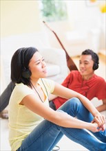 Young woman and man listening music with headphones on