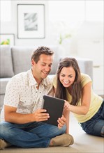 Portrait of couple using digital tablet