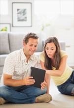 Portrait of couple using digital tablet