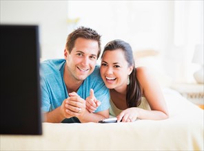 Portrait of happy couple watching TV