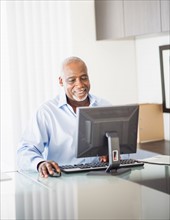 Portrait of senior man working on computer in office