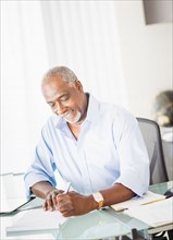 Portrait of senior man writing in office