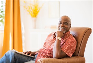 Portrait of men sitting in armchair