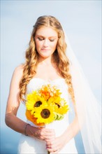 Portrait of bride holding sunflower bouquet